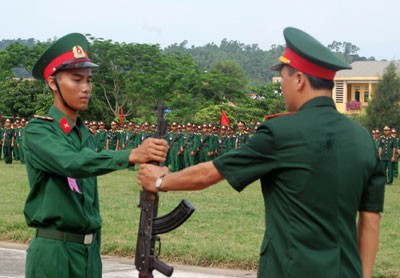 Đại diện chỉ huy Tung đoàn trao súng cho chiến sĩ Phạm Văn Thuấn.